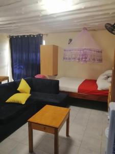 a living room with a couch and a bed at MAGNOLIA SUITES in Ukunda