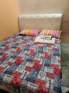 a bed with a quilt on top of it at Nas Homestay in Jitra