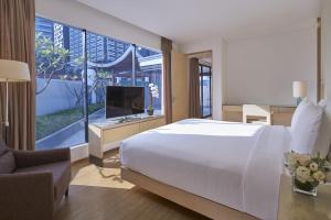 Singapore Marriott Tang Plaza Hotel في سنغافورة: غرفة نوم بسرير ابيض كبير ونافذة كبيرة
