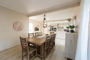 comedor y cocina con mesa de madera y sillas en Cheerful 4-bedroom home with Park View, en Glen Waverley