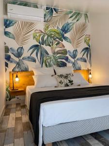 - une chambre avec un lit et du papier peint tropical dans l'établissement La Réunion Plein la Vue, à Saint-Paul