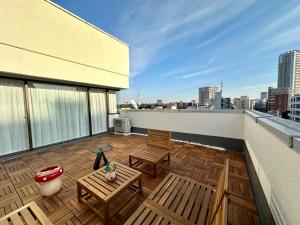 eine Terrasse mit 2 Stühlen und einem Tisch auf dem Dach in der Unterkunft LoveTokyo Maisonette Terrace in Tokio