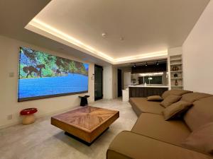 sala de estar con sofá y TV en la pared en LoveTokyo Maisonette Terrace, en Tokio