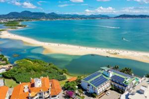 an aerial view of a beach with a building with solar panels at Apartamento Rafaelli in Florianópolis