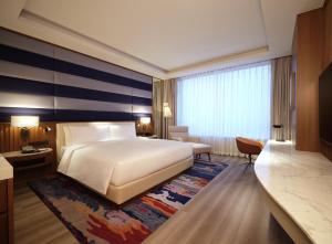 a hotel room with a bed and a large window at INSPIRE Entertainment Resort in Incheon