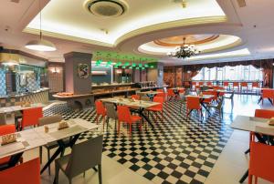 a restaurant with tables and chairs and a checkered floor at Maison New Century Tongxiang in Tongxiang
