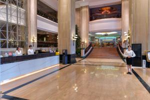 a woman walks through the lobby of a hotel at Maison New Century Tongxiang in Tongxiang