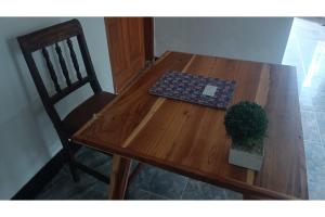 uma mesa de madeira com uma cadeira e uma planta sobre ela em SPOT ON 93524 Bagas Homestay em Lembuak