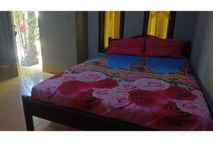 uma cama com rosas vermelhas em cima em SPOT ON 93524 Bagas Homestay em Lembuak