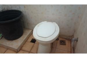 uma casa de banho com um WC e uma lata de lixo em SPOT ON 93524 Bagas Homestay em Lembuak
