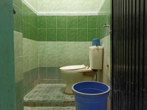 ein Badezimmer mit einem WC und einem blauen Eimer in der Unterkunft OYO 93538 Millow Kost in Parepare