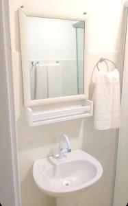 a bathroom with a sink and a mirror at Apartamento para locação em Itajai SC in Itajaí