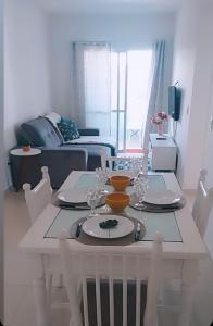 a white dining room table with chairs and a table with at Apartamento para locação em Itajai SC in Itajaí