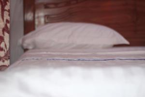 un primer plano de una cama con una almohada blanca en Faradel Motel en Fomboni