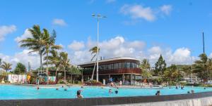 a group of people in a swimming pool in front of a building at Bella Vista - Spectacular Ocean Views & Continental Breakfast in Yeppoon