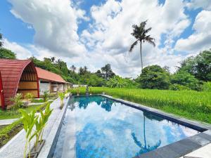 an image of a swimming pool in front of a house at Uma Raos Cottage in Ubud