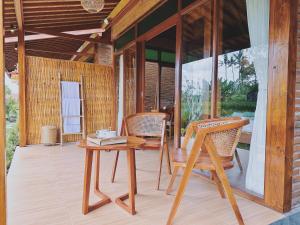 einen Holztisch und Stühle auf einer Veranda in der Unterkunft Uma Raos Cottage in Ubud