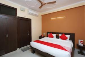 um quarto com uma cama grande e almofadas vermelhas em Hotel Rose & petals , Ghaziabad em Ghaziabad