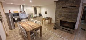 a kitchen with a wooden table and a fireplace at Chata SNOW in Valča