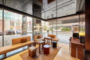 a lobby with tables and chairs and a large window at Hotel Uri& in Seoul