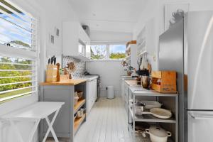 a kitchen with white floors and white walls at Adrift - Pet-friendly - 5 min Walk to Bay - Rustic Charm in Erowal Bay