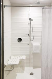 y baño blanco con ducha y aseo. en AC Hotel by Marriott Minneapolis West End en Minneápolis