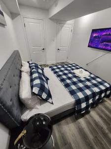 ein Schlafzimmer mit einem Bett mit einer karierten Decke in der Unterkunft New Modern room in Innisfil in Innisfil