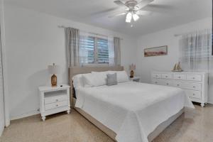 1 dormitorio blanco con 1 cama y ventilador de techo en 7-Person Luxury Spa, Fenced Paradise, Beach Vibes, en Pembroke Pines