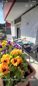 un tavolo, sedie e fiori su un patio di Appartamento Gemma a Pietrasanta