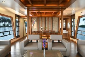 a living room with couches and a table at Premium Houseboat in Alleppey