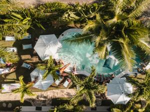 an overhead view of a swimming pool with palm trees at Clandestino Hostel Canggu in Canggu