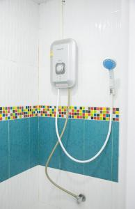 un baño con una manguera conectada a un dispensador en la pared en OYO 75457 Hello Host en Chiang Mai
