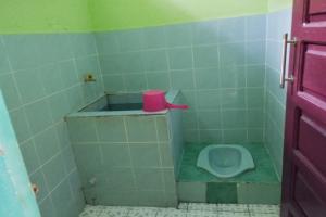 a bathroom with a toilet with a pink cup on it at Hotel O Pondok Gusang Kuala Near Pelabuhan H Basran in Pagatan +61 photos