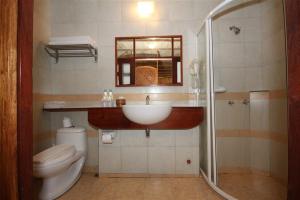 ein Bad mit einem Waschbecken, einem WC und einer Dusche in der Unterkunft Sala Prabang Hotel in Luang Prabang