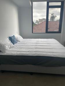 a large bed in a room with a window at Unit 103, 1-5 Oxford Street, Blacktown, NSW 2148 in Blacktown