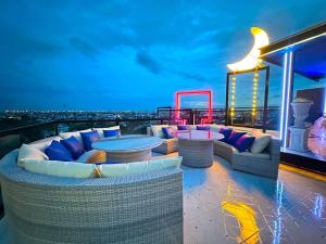 a rooftop deck with couches and tables on a building at Sky dome resotel in Bangkok