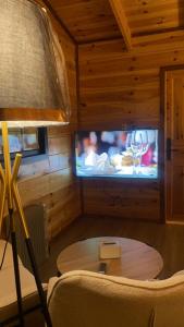 a room with a table and a tv and a lamp at مجمع اكواخ عباره عن 8 اكواخ و حديقه مشتركه للنزلاء Diriyah clouds خدمه ذاتيه Entry ذاتي سكن ريفي in Riyadh +7 photos