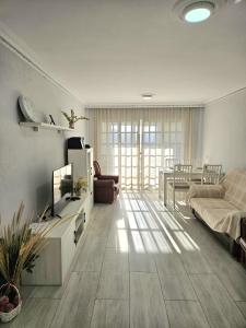 a living room with a couch and a tv in it at Habitación Privada a 15 min de la Playa/Piso in Huelva
