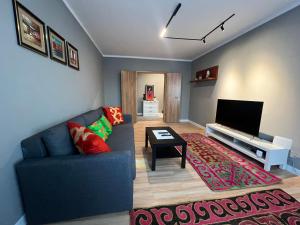 a living room with a blue couch and a television at Spacious 2 BR in heart of the city in Ulaanbaatar