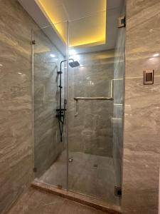 y baño con ducha y puerta de cristal. en The Beach Suites at Pico De Loro en Nasugbu