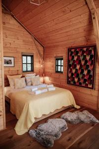 ein Schlafzimmer mit einem Bett in einem Blockhaus in der Unterkunft Cabane Rouge-Gorge in Auriac-du-Périgord