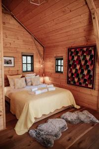 a bedroom with a bed in a log cabin at Cabane Rouge-Gorge in Auriac-du-Périgord