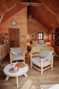 1 Schlafzimmer mit einem Bett, 2 Stühlen und einem Tisch in der Unterkunft Cabane Rouge-Gorge in Auriac-du-Périgord
