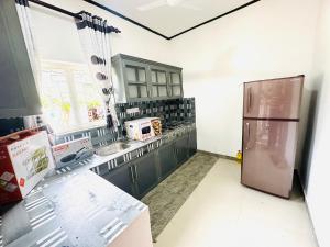 a kitchen with a refrigerator and a sink at Villa Beach Heaven in Hikkaduwa
