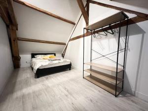 - une chambre avec un lit dans une pièce dotée de plafonds en bois dans l'établissement L armurerie - Appartement centre ville de Sens, à Sens
