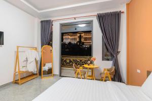 Nhat Minh Hotel Dalat في دالات: غرفة نوم بسرير وطاولة ونافذة