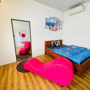 1 dormitorio con 1 cama con un gran asiento rojo en Nhà nghỉ Bảo Trâm, en Chau Doc