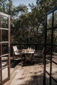 a patio with a table and chairs on a wooden deck at Cabane Rouge-Gorge in Auriac-du-Périgord