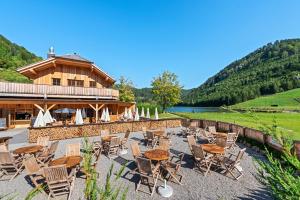 a resort with chairs and tables in front of a building at CHALET am Schneeberg See in Puchberg am Schneeberg