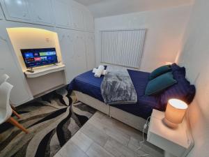 - une petite chambre avec un lit et une télévision dans l'établissement Relaxed Double bed with private bathroom, parking, WiFi and garden., à Leeds